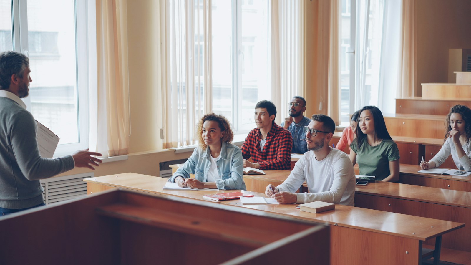 Professor lecturing to university students in a classroom